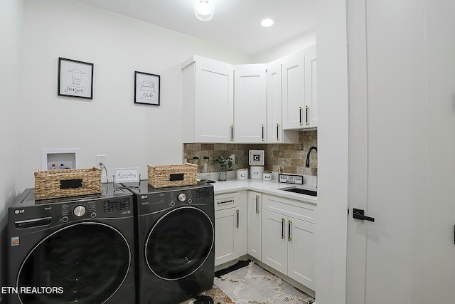 washroom featuring cabinets, sink, and washing machine and dryer