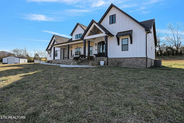 modern inspired farmhouse featuring a porch, a garage, an outdoor structure, central AC, and a front lawn