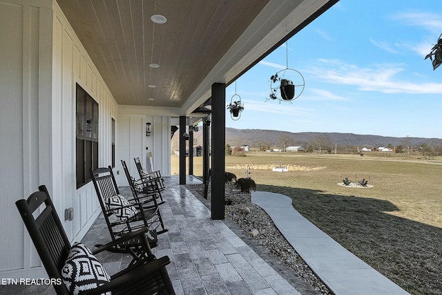 view of patio / terrace with a mountain view and a porch