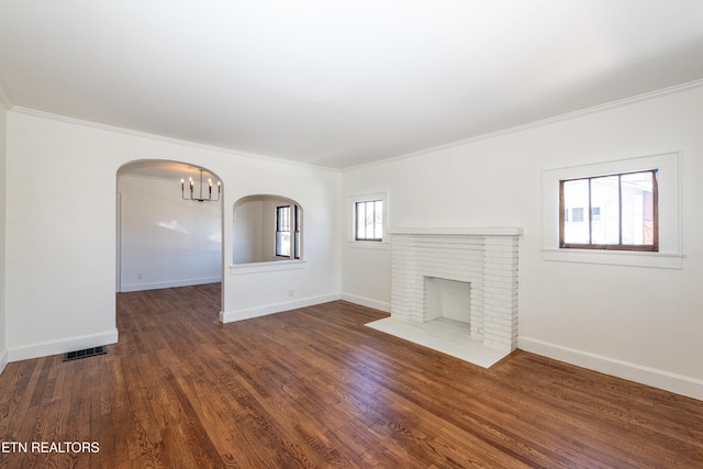 unfurnished living room featuring a brick fireplace, baseboards, visible vents, and dark wood finished floors