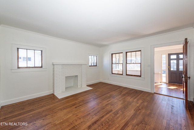 unfurnished living room with dark wood-style floors, baseboards, and crown molding