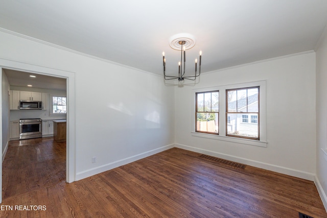 empty room with crown molding, baseboards, visible vents, and a notable chandelier