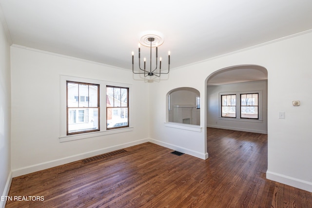 unfurnished dining area with dark wood-type flooring, visible vents, ornamental molding, and baseboards