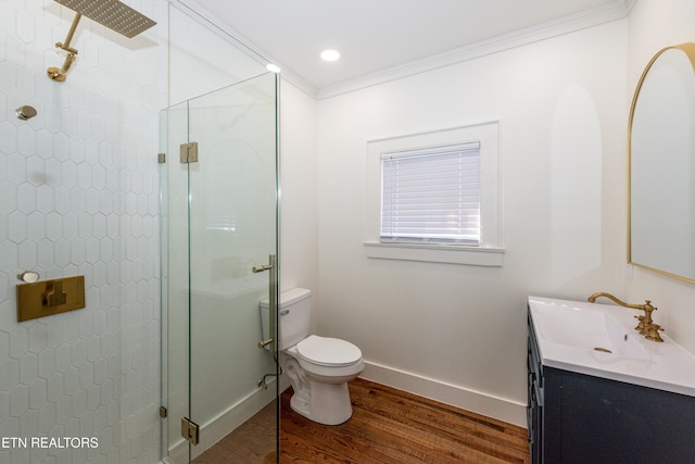 full bath featuring toilet, wood finished floors, vanity, a shower stall, and crown molding