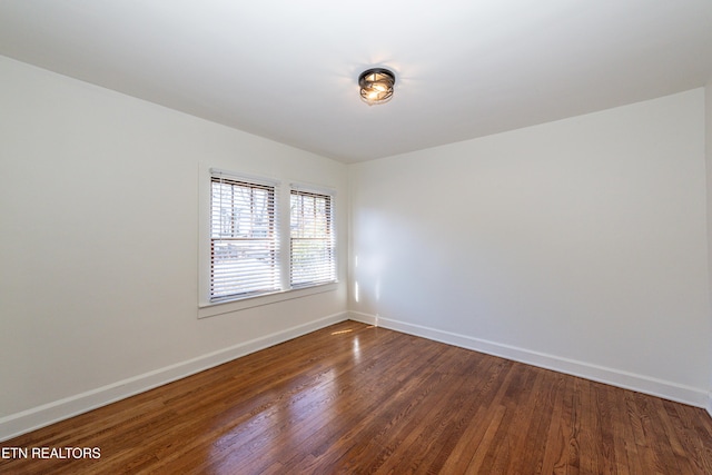 spare room with wood finished floors and baseboards