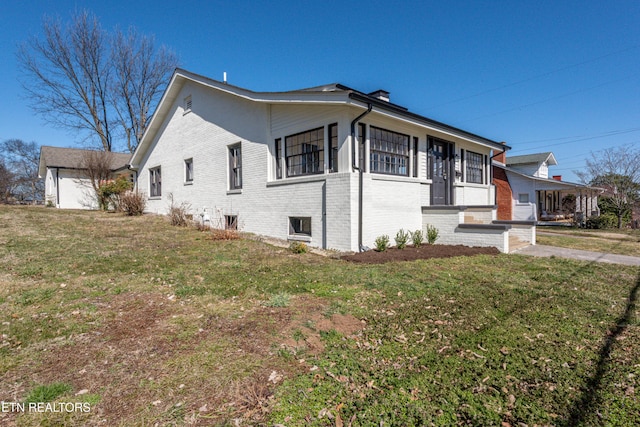 view of property exterior with a yard and brick siding