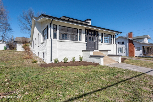 view of front of home featuring brick siding and a front yard