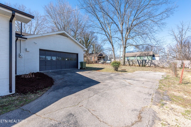 view of side of property with a garage and brick siding