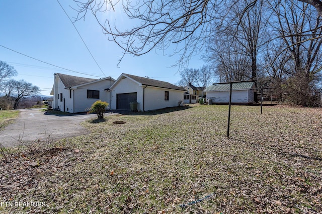 view of property exterior with aphalt driveway and an attached garage