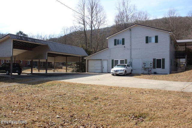 view of property exterior with a carport, a garage, and a lawn