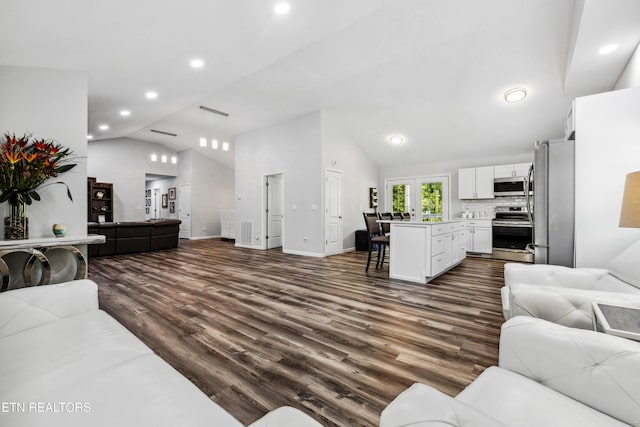 living room with french doors, dark hardwood / wood-style floors, and vaulted ceiling