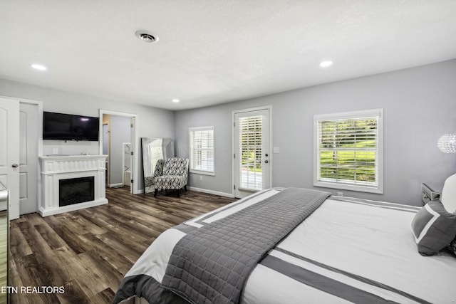 bedroom with dark hardwood / wood-style flooring, multiple windows, and access to outside