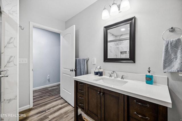 bathroom featuring hardwood / wood-style flooring, vanity, and a shower