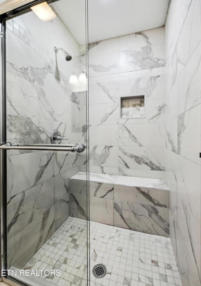 bathroom featuring a shower with shower door