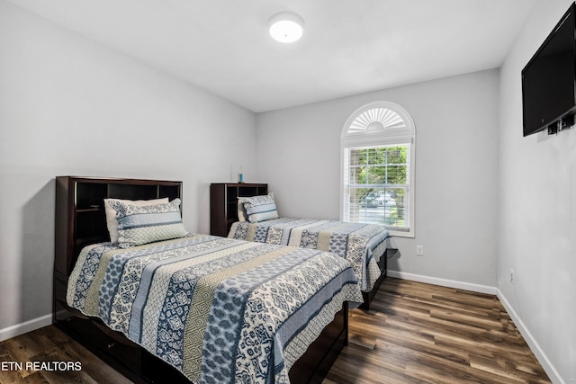 bedroom with dark wood-type flooring