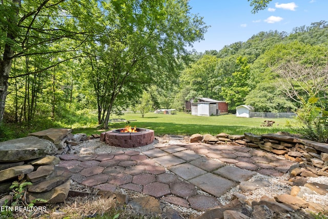 view of patio / terrace with a storage shed and a fire pit