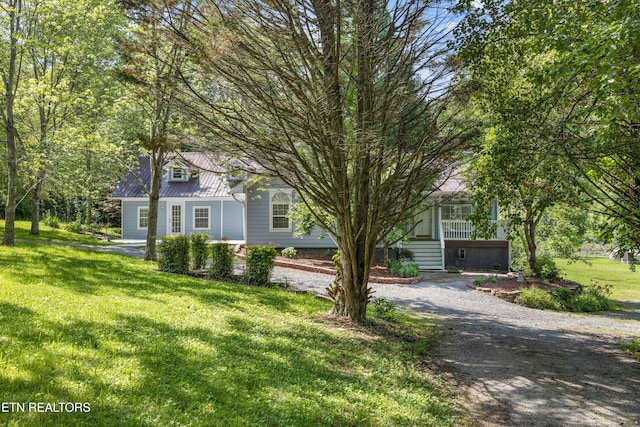 view of property hidden behind natural elements featuring a front yard