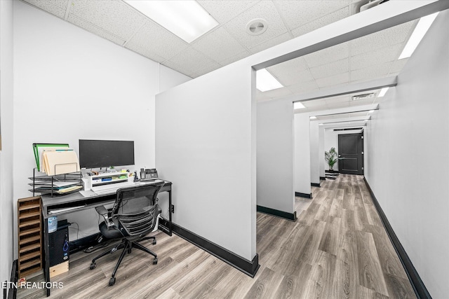 home office featuring a paneled ceiling and light wood-type flooring