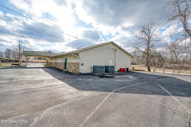 view of side of home with cooling unit and a carport