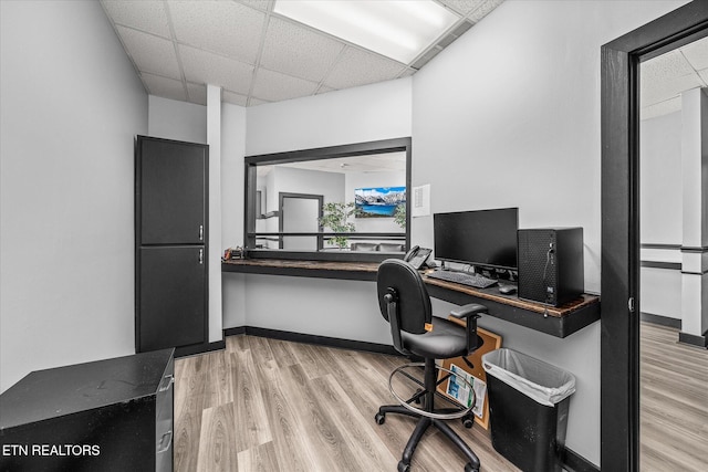 office area with light wood-type flooring and a drop ceiling