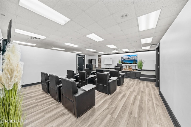 home theater featuring a drop ceiling, a fireplace, and light wood-type flooring