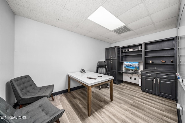 office area featuring a paneled ceiling and light wood-type flooring