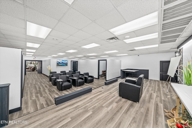 living room with hardwood / wood-style flooring and a drop ceiling