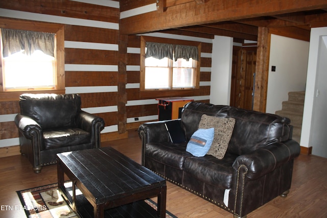 living room featuring plenty of natural light, wood-type flooring, and wood walls