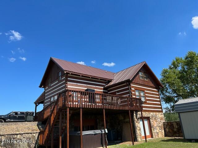 back of house featuring a deck and a lawn