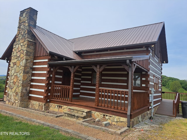 view of side of home featuring covered porch