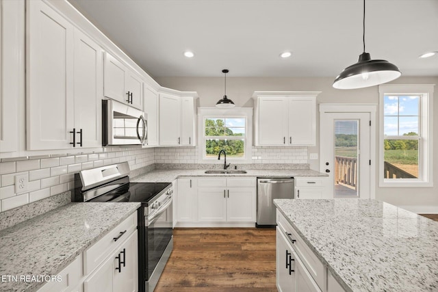 kitchen featuring stainless steel appliances, white cabinetry, and sink