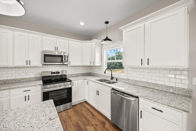 kitchen featuring white cabinetry, sink, hanging light fixtures, and appliances with stainless steel finishes