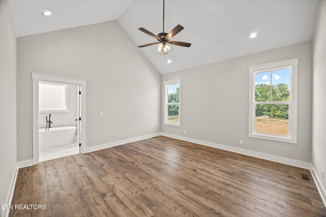 unfurnished bedroom featuring ensuite bathroom, hardwood / wood-style floors, ceiling fan, and high vaulted ceiling