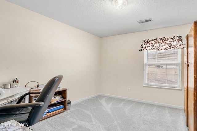 carpeted home office with a textured ceiling