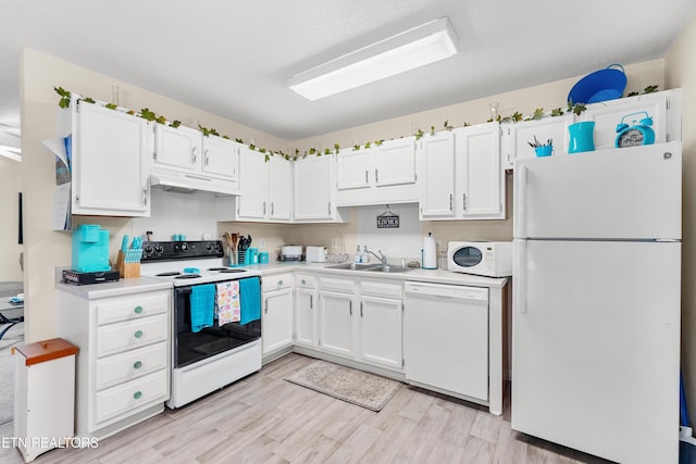 kitchen featuring sink, white appliances, light hardwood / wood-style floors, and white cabinets