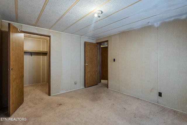 unfurnished bedroom featuring light carpet and a closet