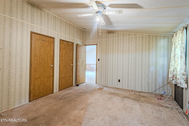 unfurnished bedroom featuring multiple closets, lofted ceiling, carpet, and ceiling fan