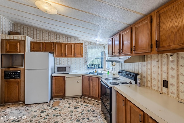 kitchen featuring vaulted ceiling, sink, and white appliances