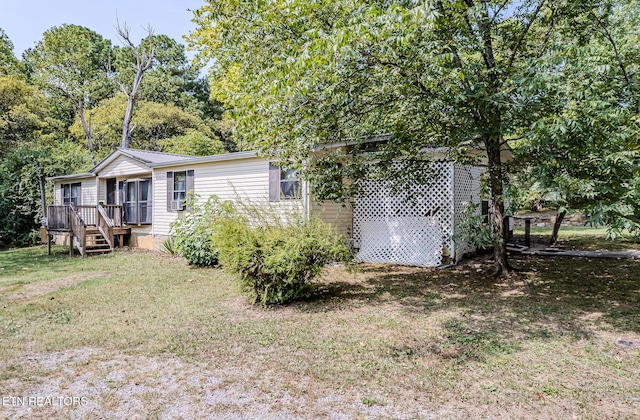 rear view of house featuring a yard and a deck