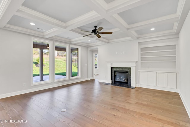 unfurnished living room featuring coffered ceiling, a fireplace, built in features, and beamed ceiling