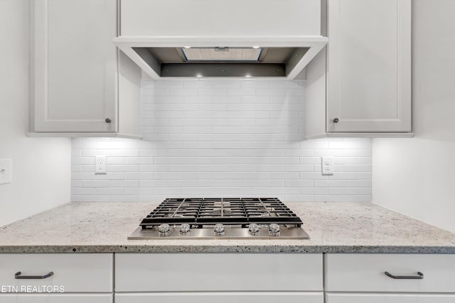 kitchen featuring white cabinetry, stainless steel gas stovetop, and decorative backsplash