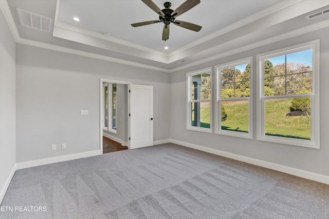 carpeted empty room featuring crown molding, ceiling fan, and a tray ceiling