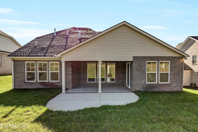 rear view of house featuring a yard and a patio area