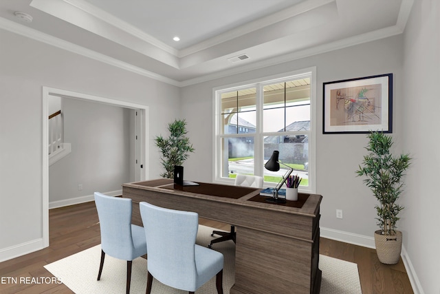 home office with crown molding, dark wood-type flooring, and a raised ceiling