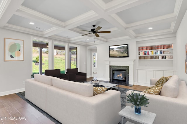 living room with hardwood / wood-style flooring, coffered ceiling, a fireplace, and beam ceiling