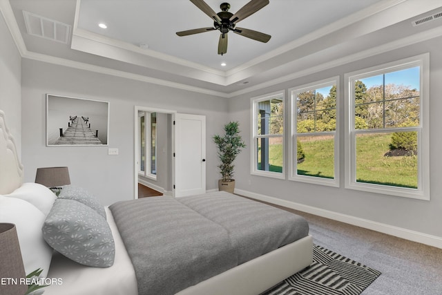 bedroom featuring ceiling fan, ornamental molding, and a tray ceiling