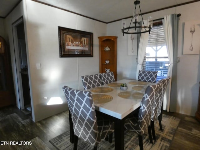 dining area with ornamental molding, dark hardwood / wood-style floors, and a notable chandelier