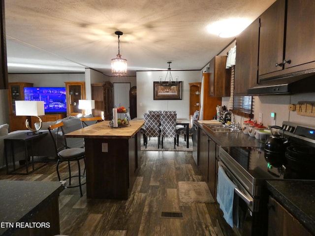 kitchen featuring pendant lighting, sink, dark wood-type flooring, stainless steel electric range oven, and wood counters