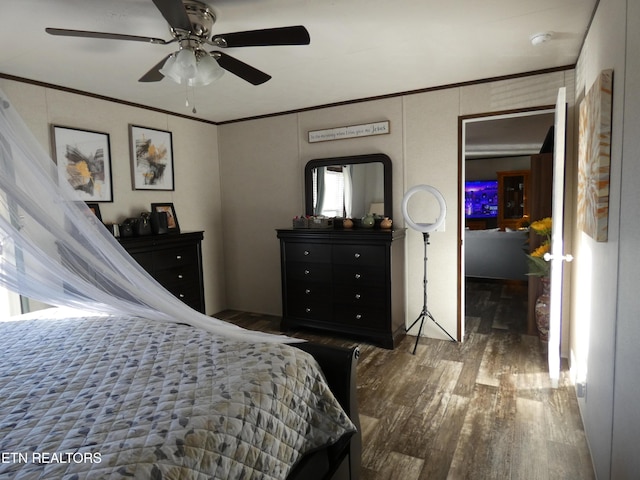 bedroom with crown molding, dark hardwood / wood-style floors, and ceiling fan