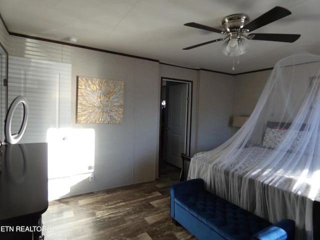 bedroom with crown molding, dark wood-type flooring, and ceiling fan